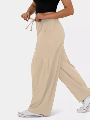Tan wide-leg jeggings with drawstring and pockets, styled casually.