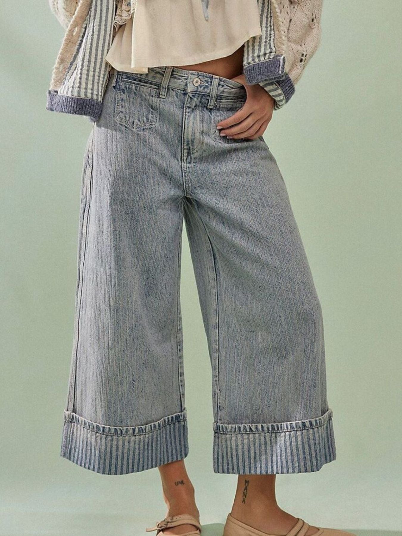 Light blue high-waisted cropped jeans with wide legs and striped cuffs.
