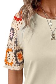Ivory tee with colorful crochet granny square sleeves.