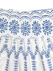 Bohemian maxi skirt with white fabric and blue floral embroidery detail.