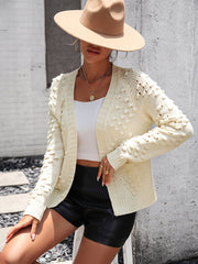 Cream acrylic cardigan with textured sleeves and open front.
