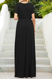 Black maxi dress with short sleeves, gathered waist, and pockets, shown from the back.