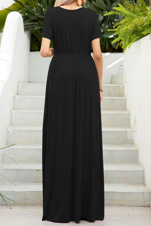 Black maxi dress with short sleeves, gathered waist, and pockets, shown from the back.