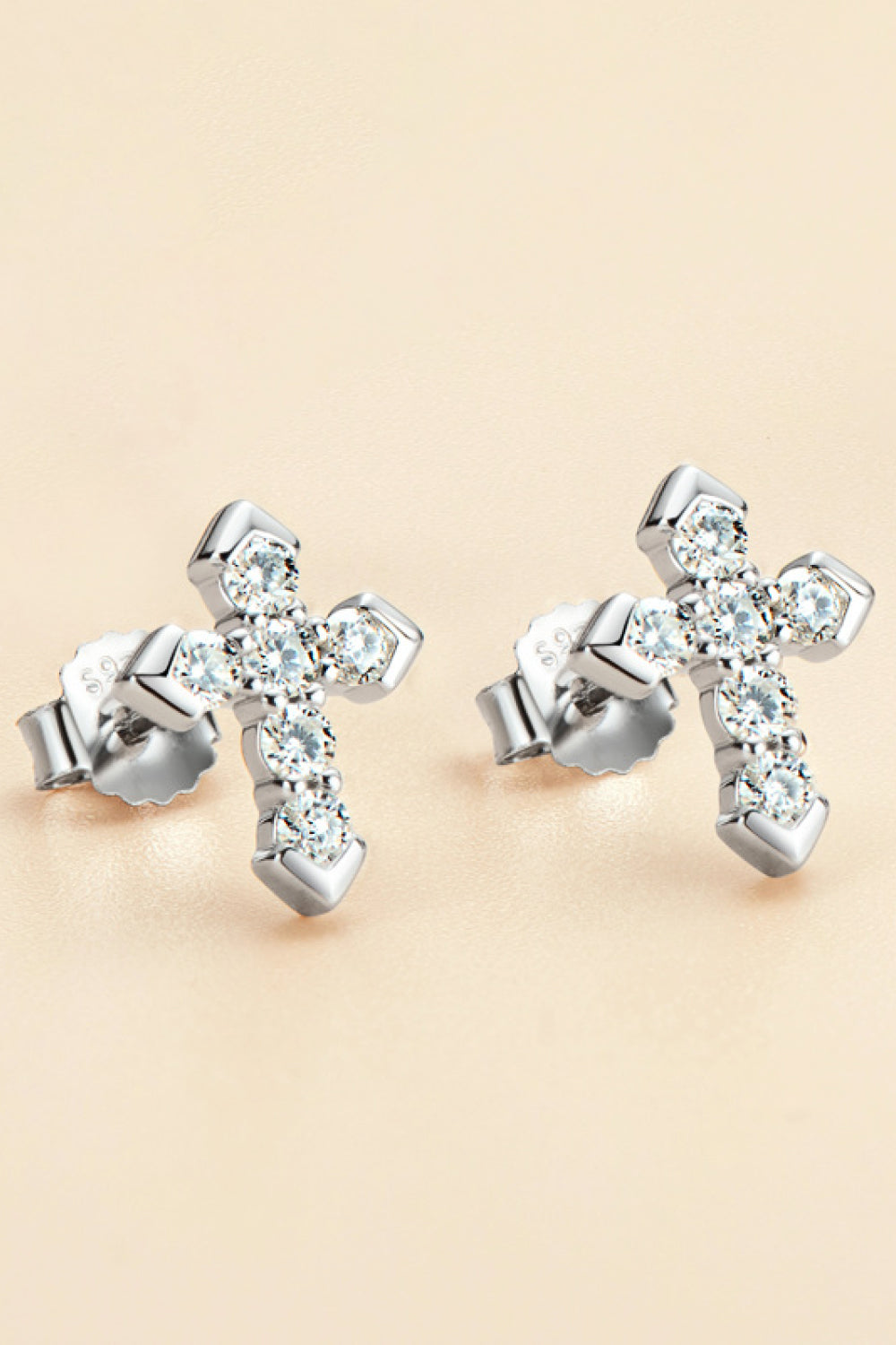 Silver diamond-set geometric cross stud earrings with sparkling stones.