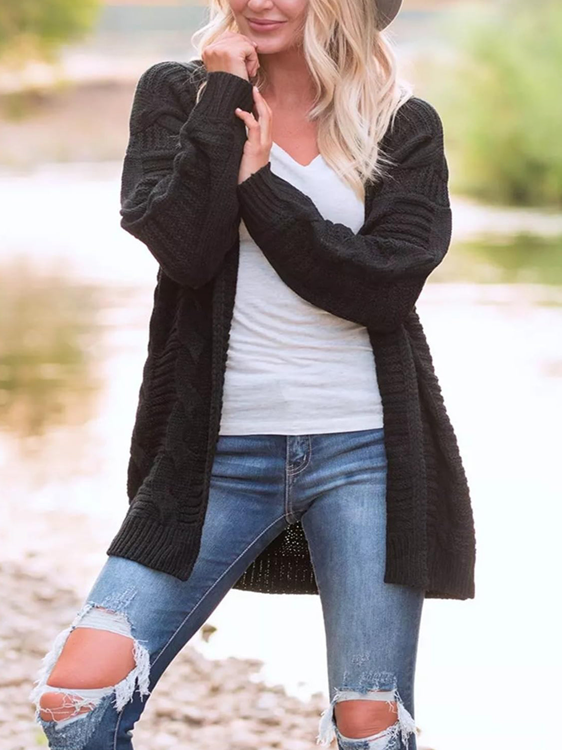 Black cable knit duster cardigan with textured pattern and long sleeves.