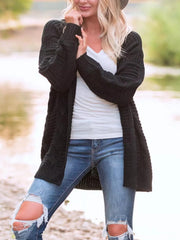 Black cable knit duster cardigan with textured pattern and long sleeves.