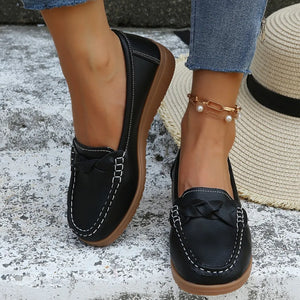 Black leather loafers with braided detail and white stitching, casual flat shoes.