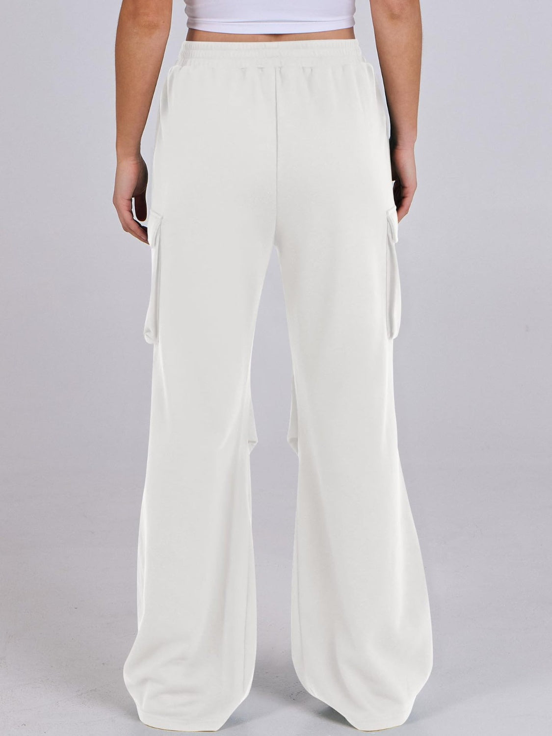 White sweatpants with cargo pockets and a wide leg cut.