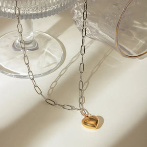 Two-tone chain necklace with a gold heart pendant.