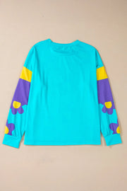 Crewneck long sleeve top in pastel blue with colorblock sleeves featuring purple and yellow daisy print.