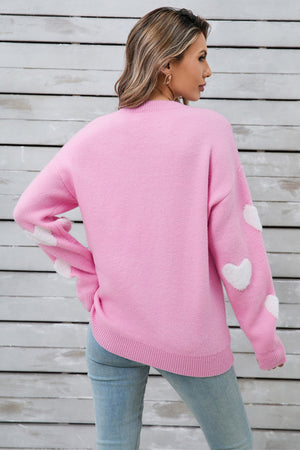 Hot Pink crewneck sweater with white heart appliqués on sleeves.