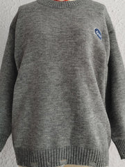 Dark gray acrylic knit sweater with embroidered blue oval detail and distressed hem.