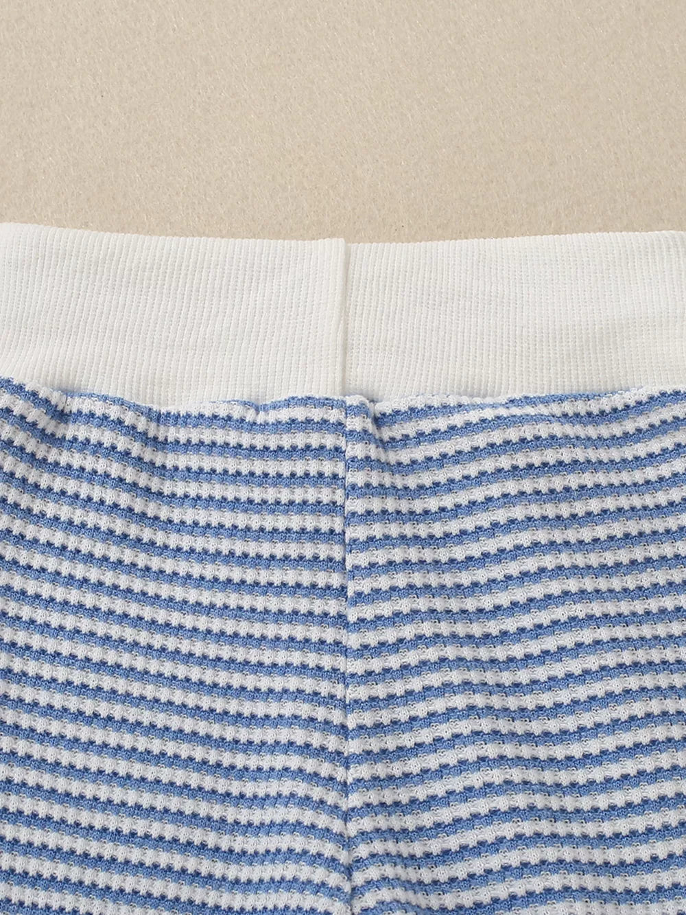 Baby knit set with blue and white stripes and a white ribbed waistband.