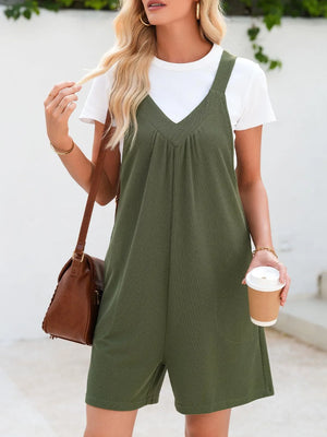 Moss green textured romper with gathered yoke and v-neck, styled with a white tee and brown crossbody bag.