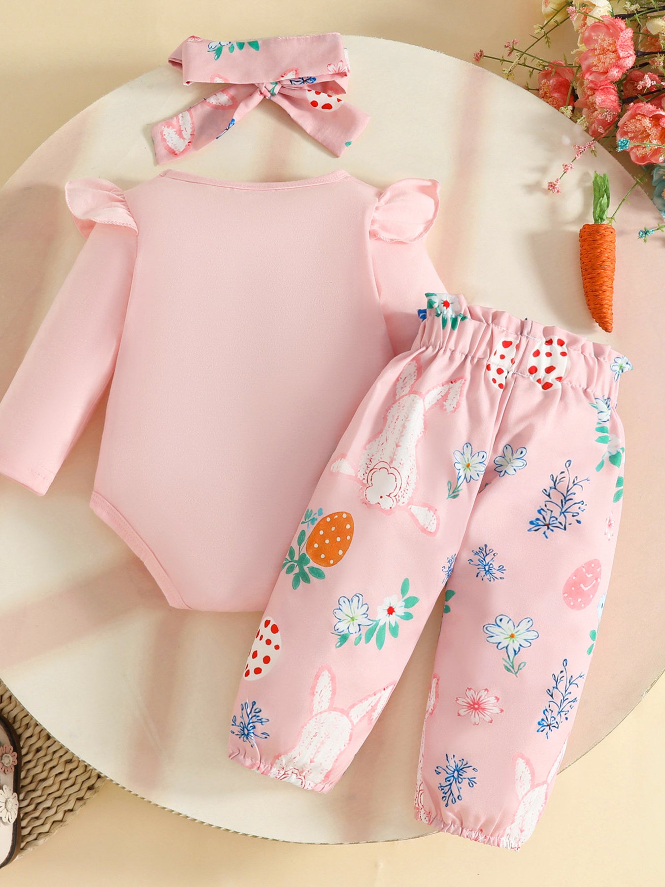 Pink baby bunny and Easter egg print outfit with ruffled sleeves and matching headband.