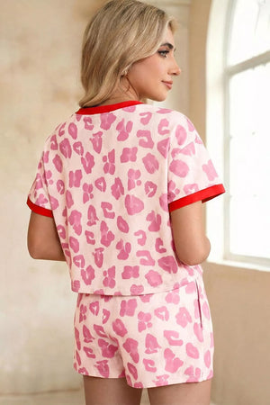 Pink leopard print pajama set with red trim, polyester shorts and short sleeve top.