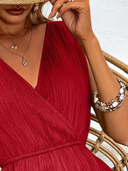 Deep red textured wrap-front romper with elastic waist and V-neckline.