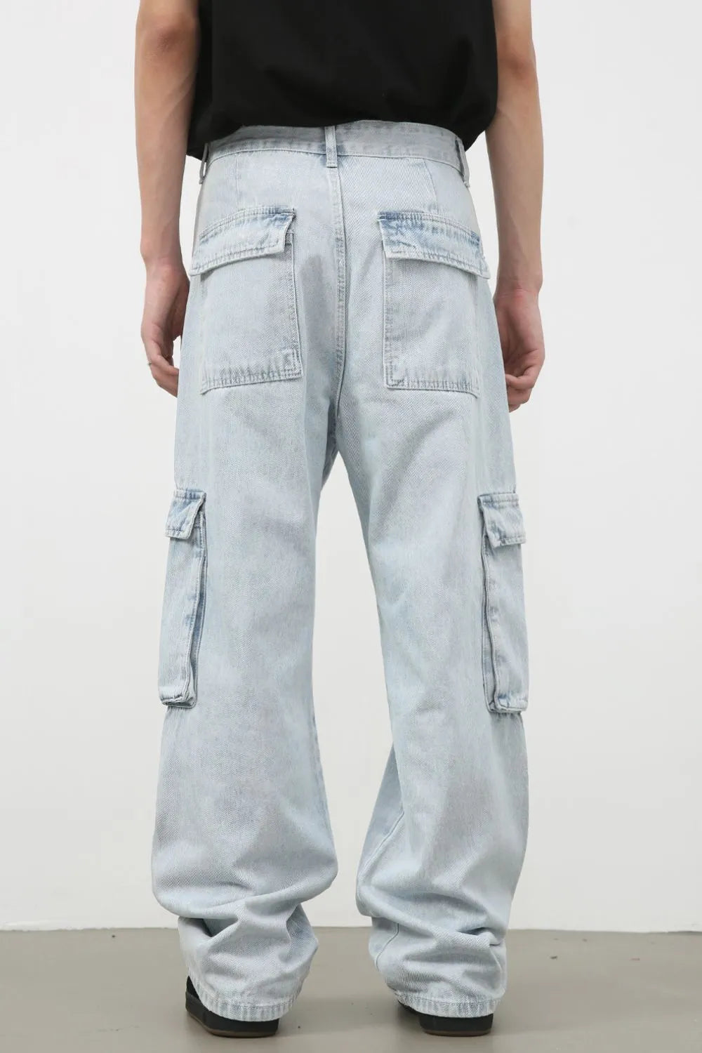 Oversized light wash denim cargo pants with multiple pockets and a relaxed fit.