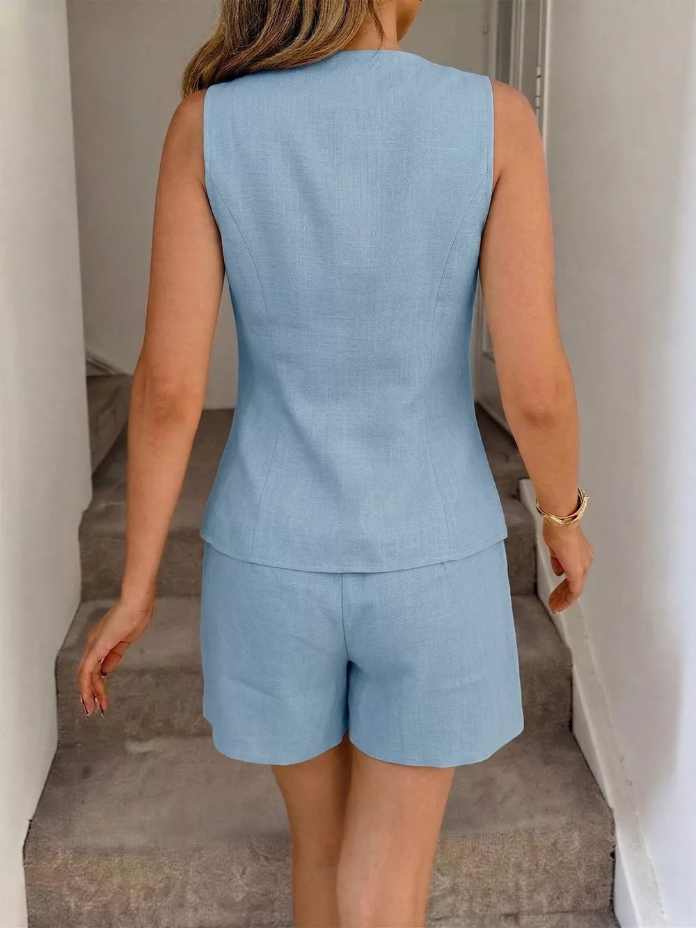 Light blue buttoned vest and tailored shorts set for women, casual chic outfit.