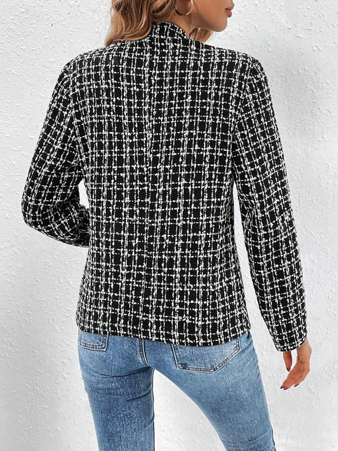 Black and white textured tweed blazer with a plaid pattern, open front, and long sleeves.