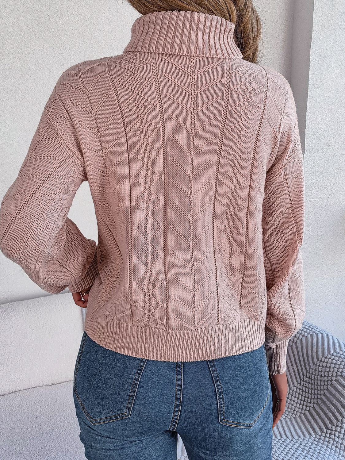 Dusty Pink cable knit turtleneck sweater with drop shoulder and textured pattern.