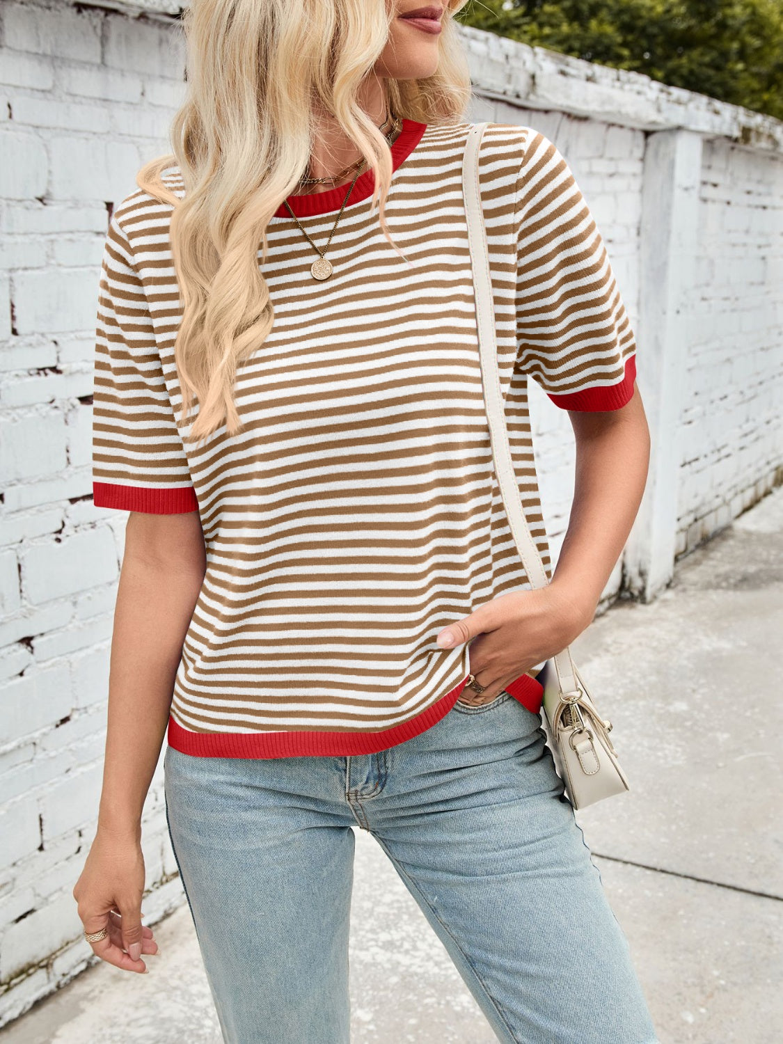 Striped knit tee with red trim and crew neck, paired with light wash jeans.