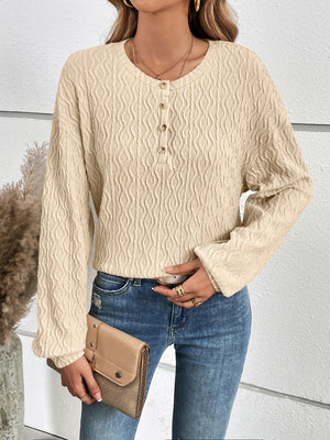 Textured ivory henley blouse with button detail and blouson sleeves.