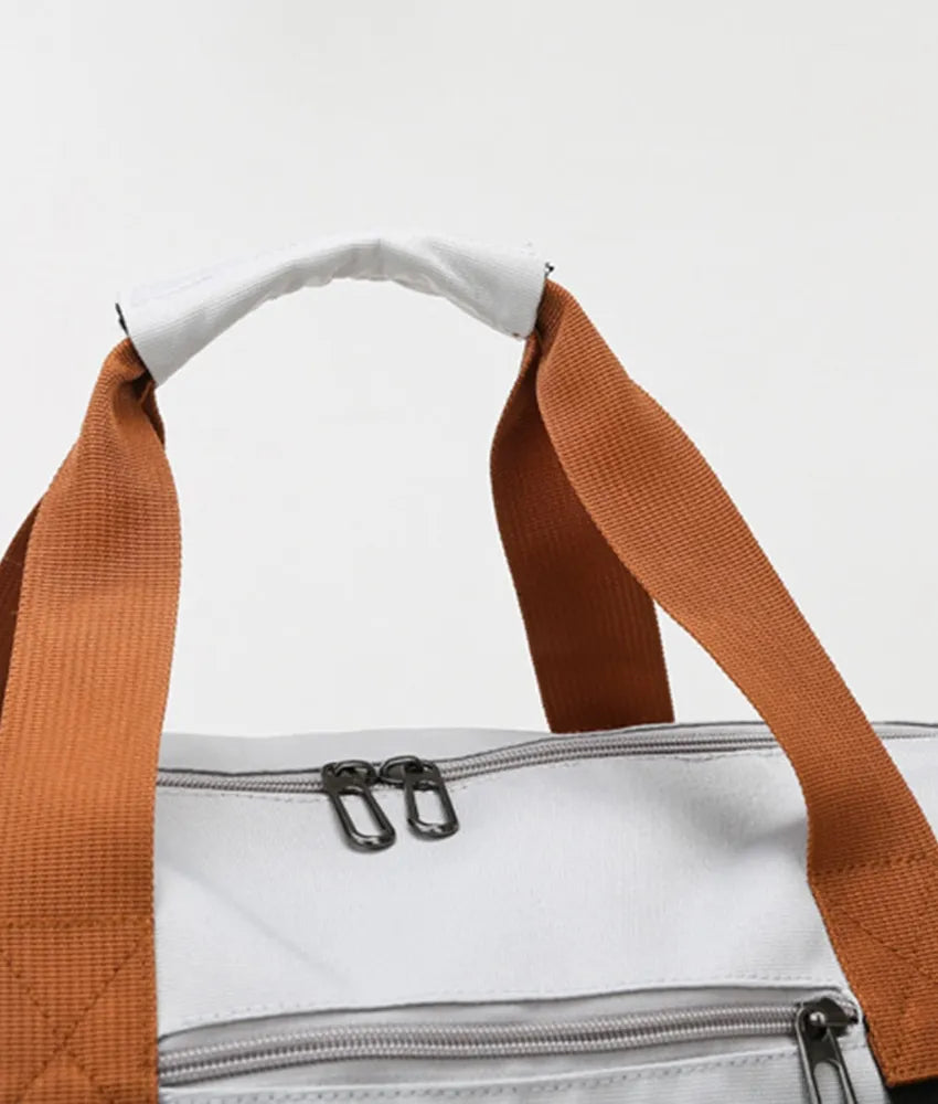 Gray dual-compartment weekender bag with orange contrast straps and white handle wrap.