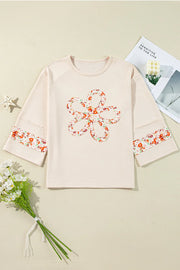 Ivory sweatshirt with floral appliqué flower and sleeve trim, raglan sleeves.
