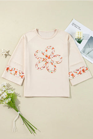 Ivory sweatshirt with floral appliqué flower and sleeve trim, raglan sleeves.