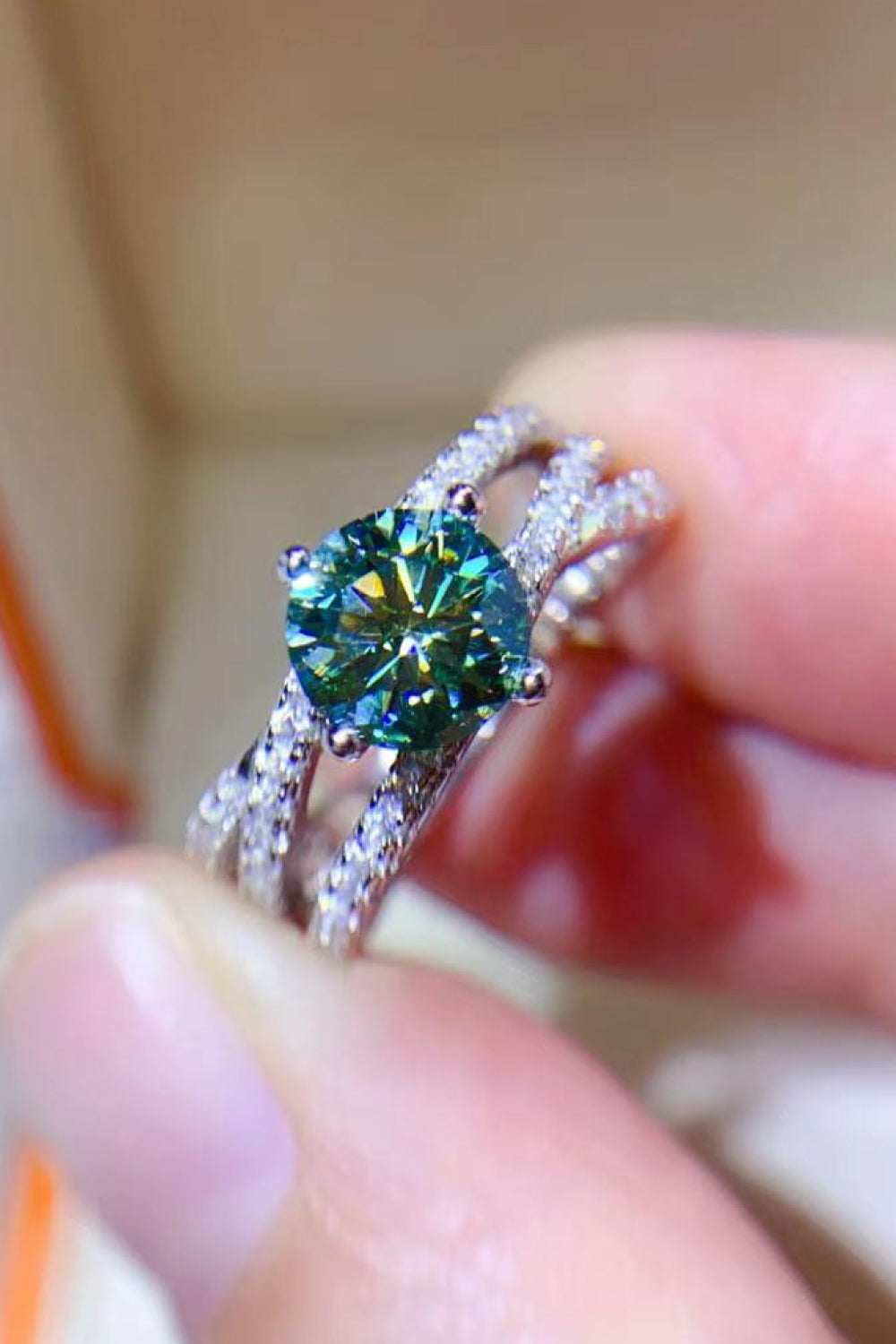 Twisted pavé halo ring with a light green stone and sterling silver band.