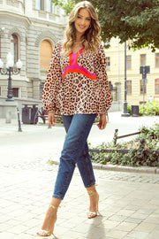 Leopard print blouson top with V-neck and color-block detail, balloon sleeves.