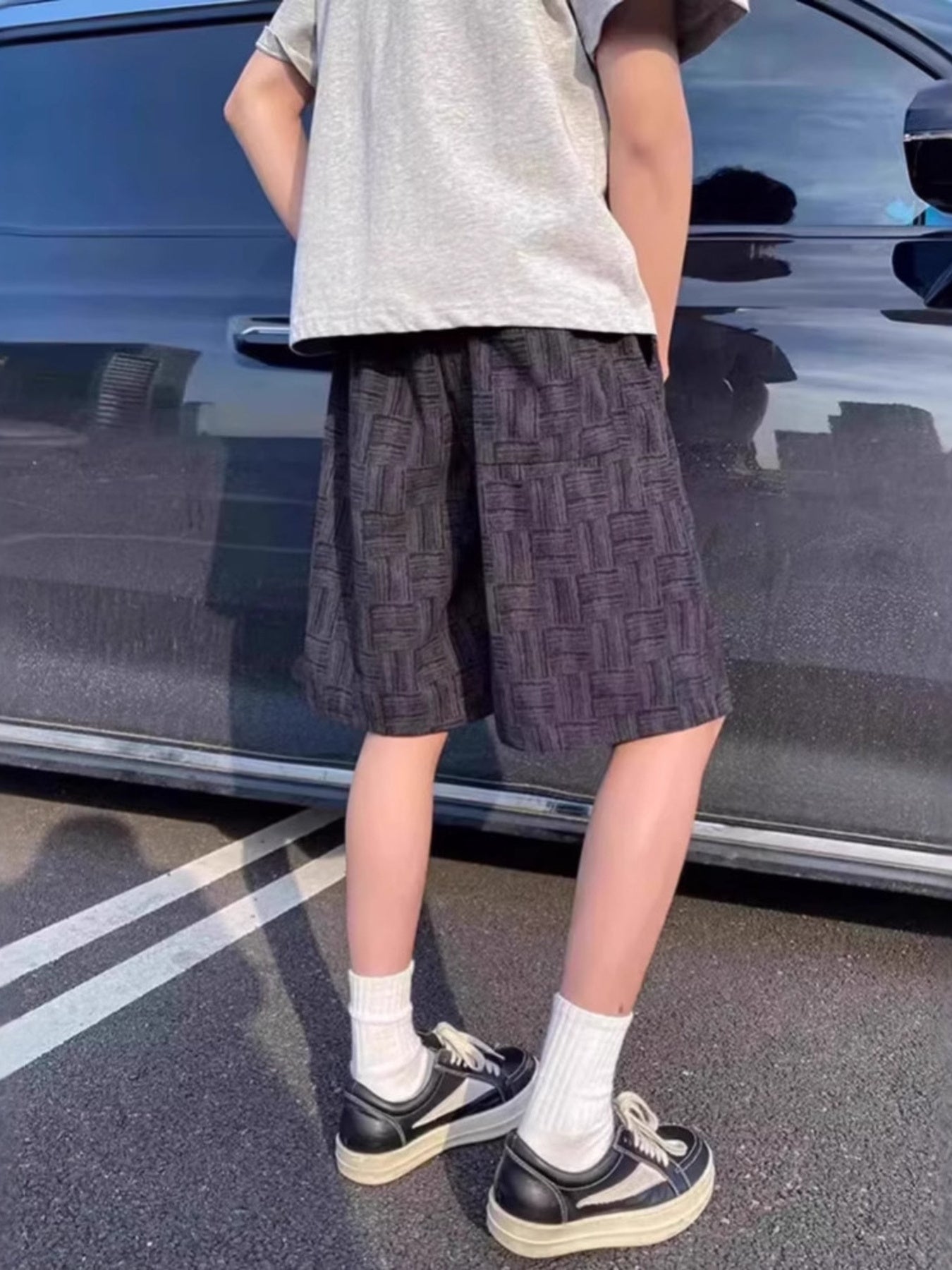 Black textured drawstring shorts with basketweave pattern.