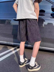 Black textured drawstring shorts with basketweave pattern.