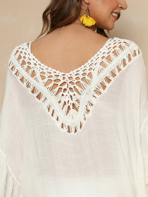 Ivory crochet yoke cover-up with fringe detail and V-neckline.