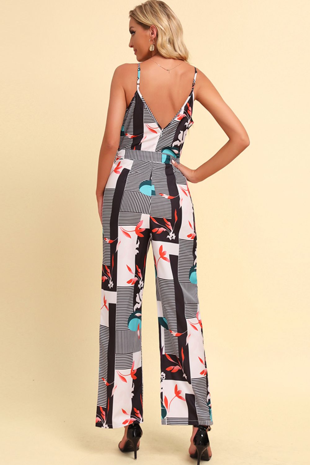 Geometric print cami jumpsuit with tie in white, featuring a V-neck and wide legs.