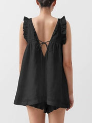 Black ruffled V-neck top with lace trim and tie back, paired with shorts.