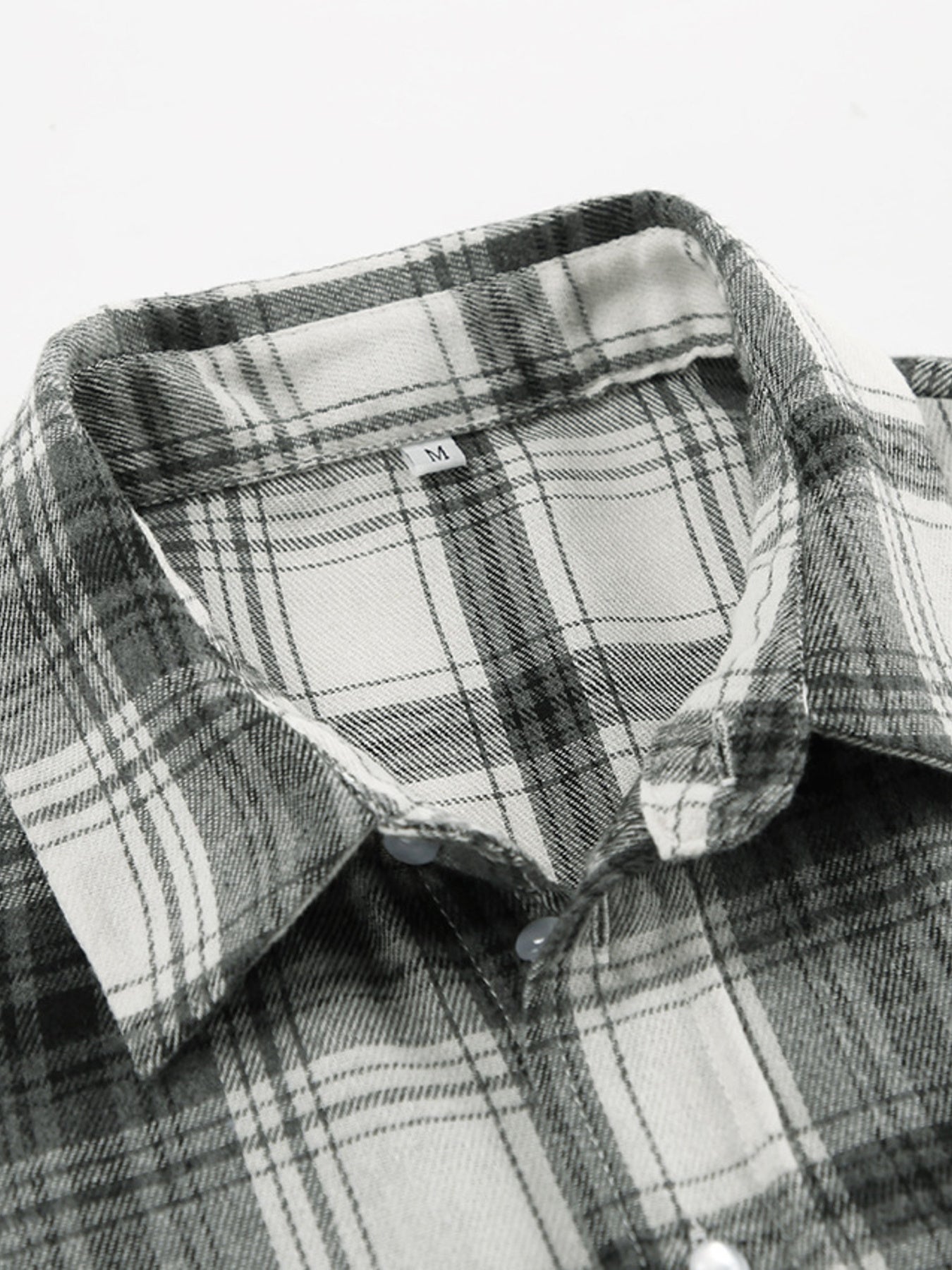Button-up long sleeve shirt in black and white plaid cotton with a classic collar.