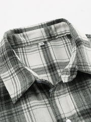 Button-up long sleeve shirt in black and white plaid cotton with a classic collar.