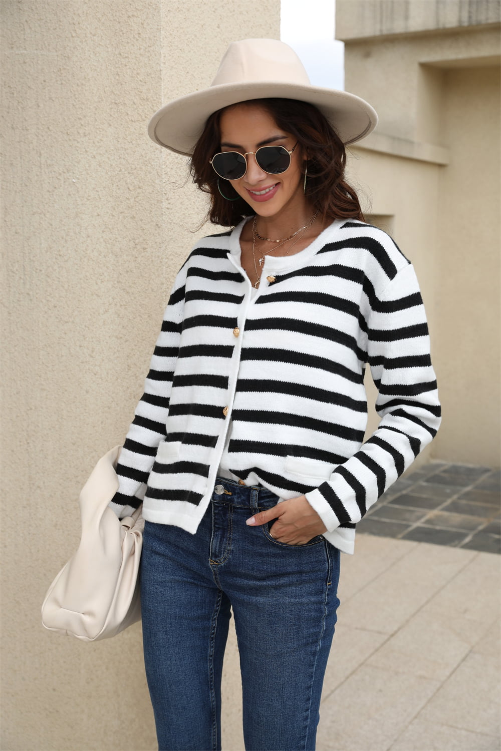 Black/White A striped crewneck cardigan with button front and gold buttons.