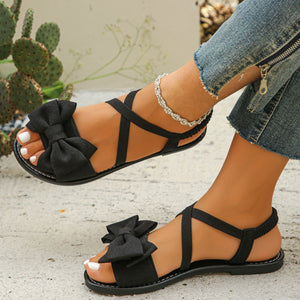 Black crisscross bow sandals with ankle straps and elastic back.