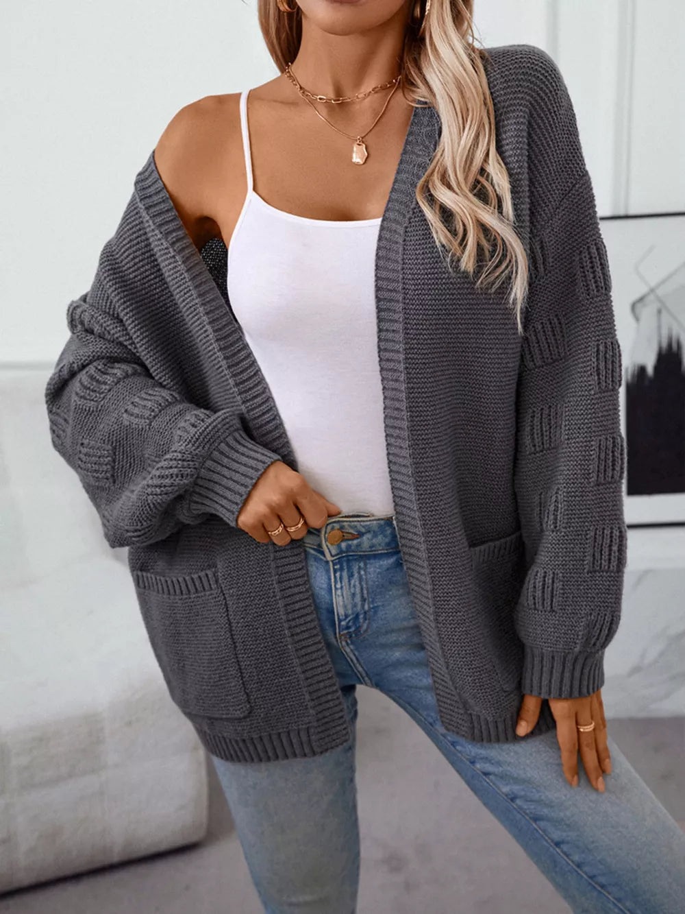 Chunky knit open-front cardigan in dark gray with pockets and textured sleeves.