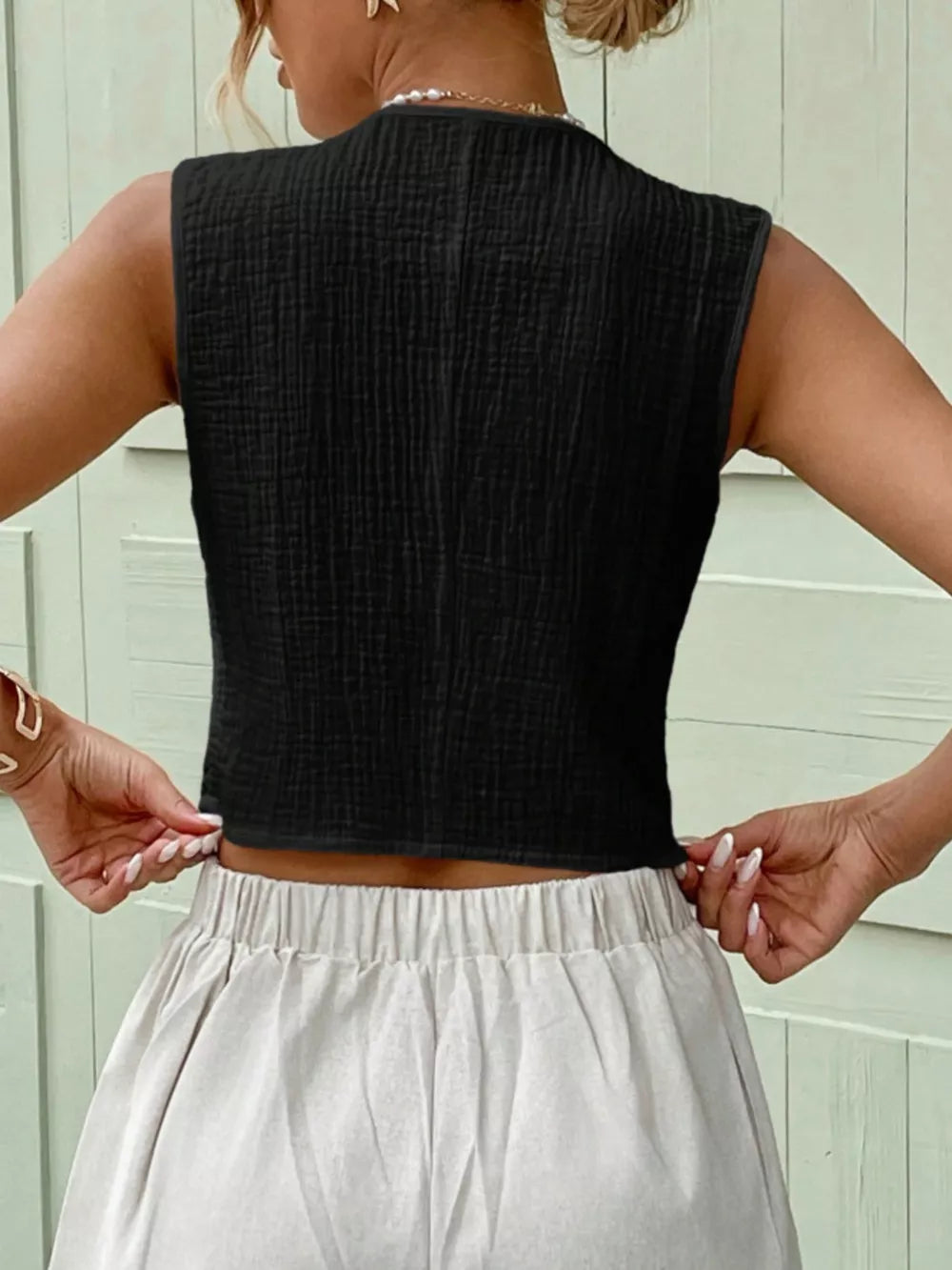 Textured black cropped button vest with a crinkled cotton fabric.