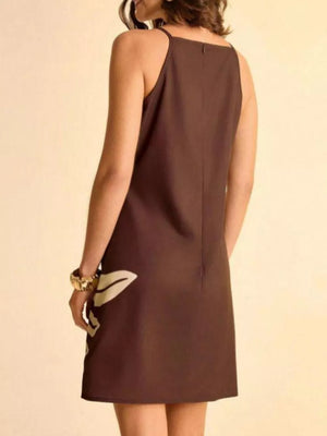 Brown mini dress with cream tropical leaf print, a-line cut, and spaghetti straps.