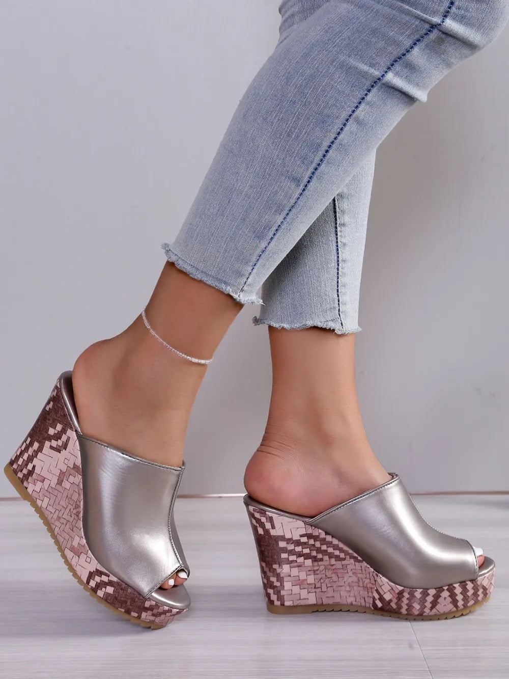 Textured wedge mules with open toe in silver, featuring a patterned wedge heel.