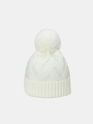 Ivory cable knit beanie with a white pompom and ribbed cuff