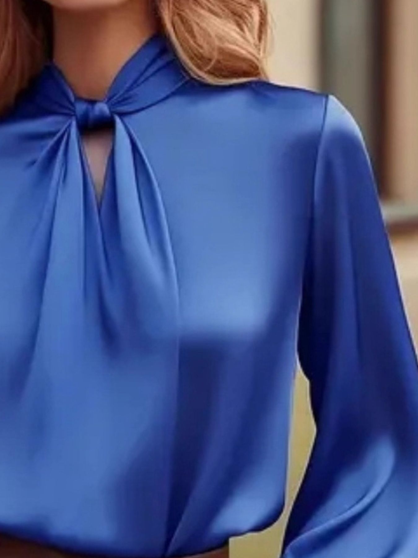 Blue satin blouse with cutout neckline and tie detail.
