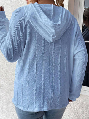 Light blue textured knit raglan hoodie with diamond cable pattern.
