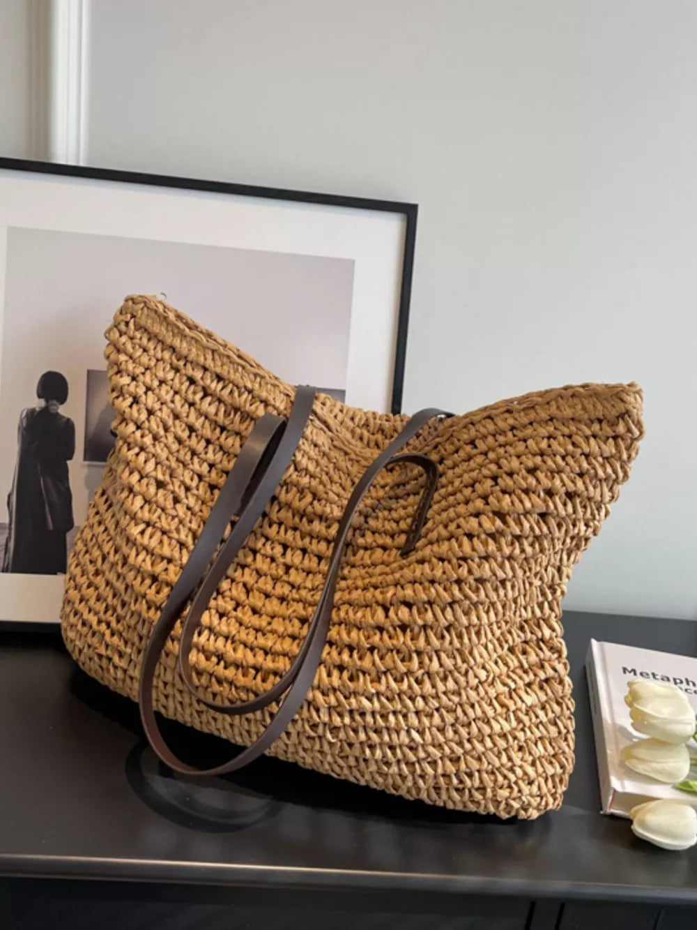 Natural woven straw shoulder bag in khaki with dark brown leather straps.