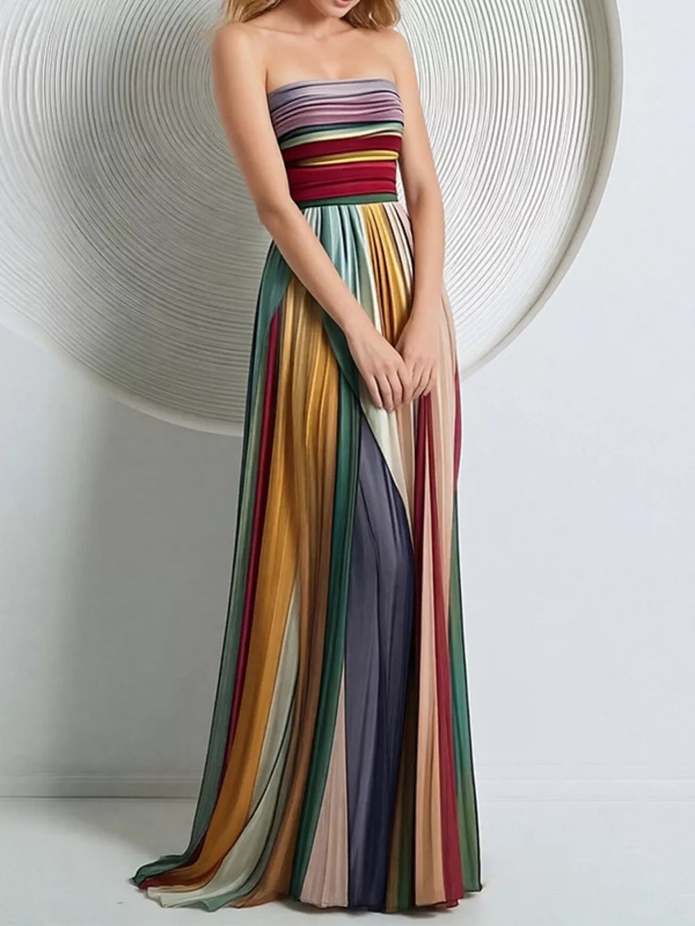 Vibrant striped strapless maxi dress with a pleated skirt and flowing silhouette.